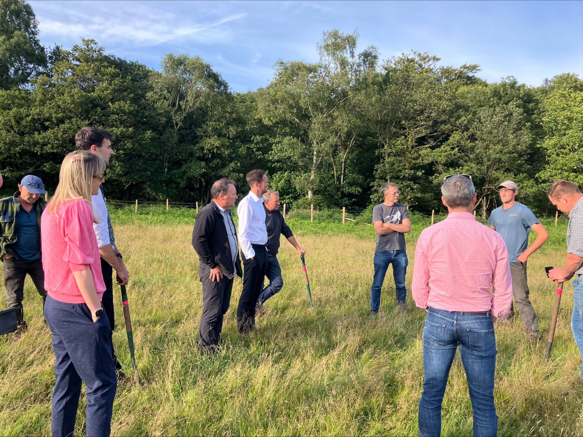 People with shovels, standing in a field